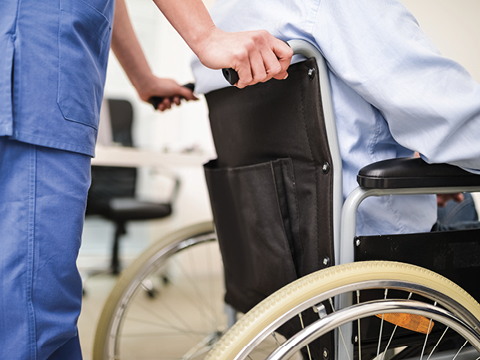 clinical employee pushing wheelchair